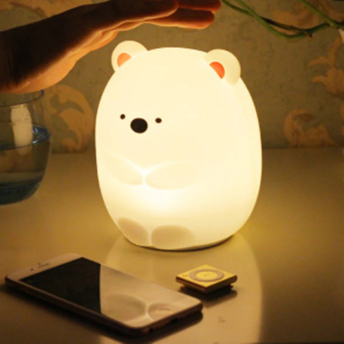 petite ours veilleuse sur une table de chevet