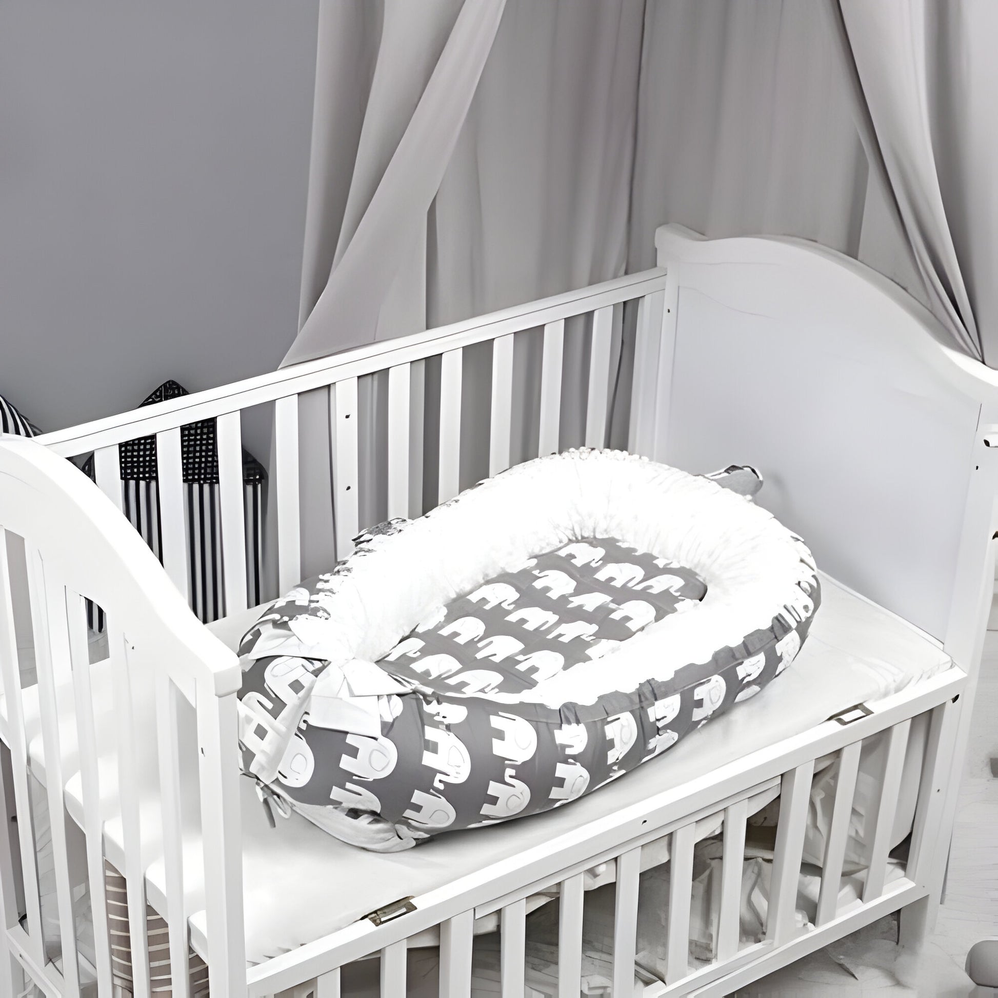 réducteur de lit bébé éléphant déposé dans un lit