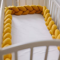 tour de lit bebe tresse orange de 4m dans un lit à barreaux pour enfant