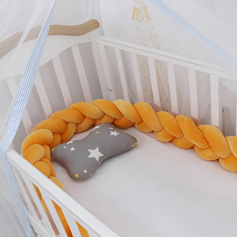 tour de lit bébé orange dans un lit pour bébé à barreaux