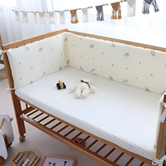 Tour de lit blanc avec des symboles gris