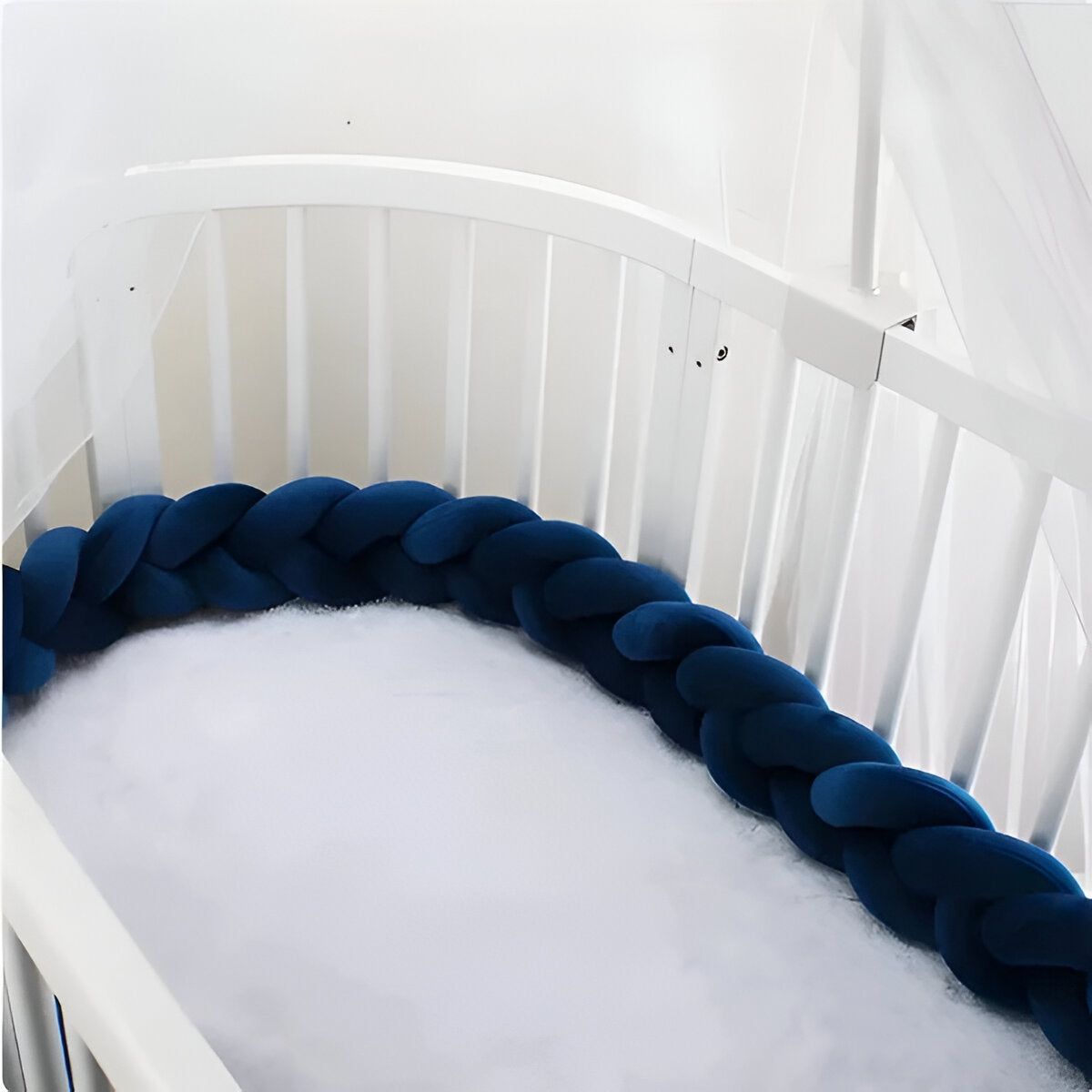 tour de lit tressé bleu dans un lit à barreaux