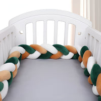 tour de lit tresse verte orange et blanche dans un berceau