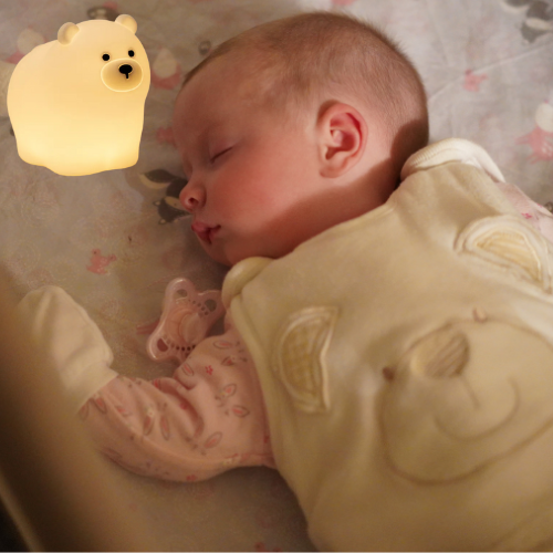 veilleuse bébé ours posé dans un lit de bébé qui dort