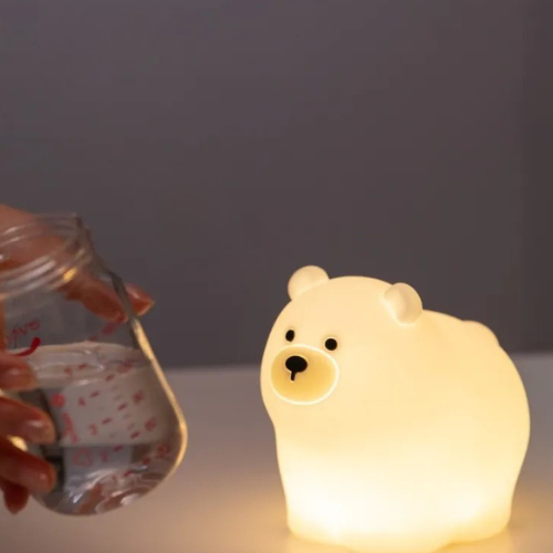 veilleuse bébé ours à côté d'un biberon
