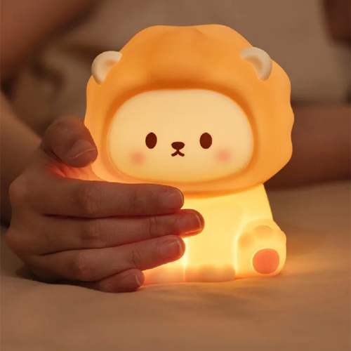 veilleuse lion dans la main d'une femme dans un lit