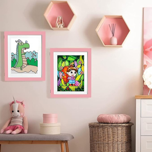 cadre dessin enfant interchangeable rose accroché sur un mur dans uen chambre de petite fille