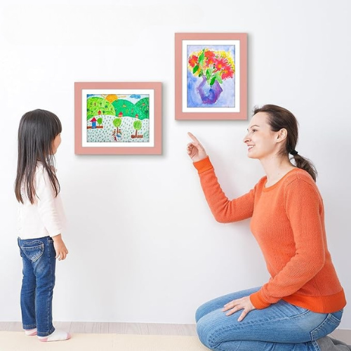 cadre dessin enfant rose sur un mur avec une petite fille