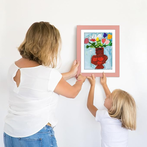 mère qui accroche cadre dessin enfant sur le mur