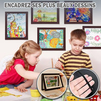 plusieurs cadre dessin enfant sur le mur derrière deux enfants qui font des dessins