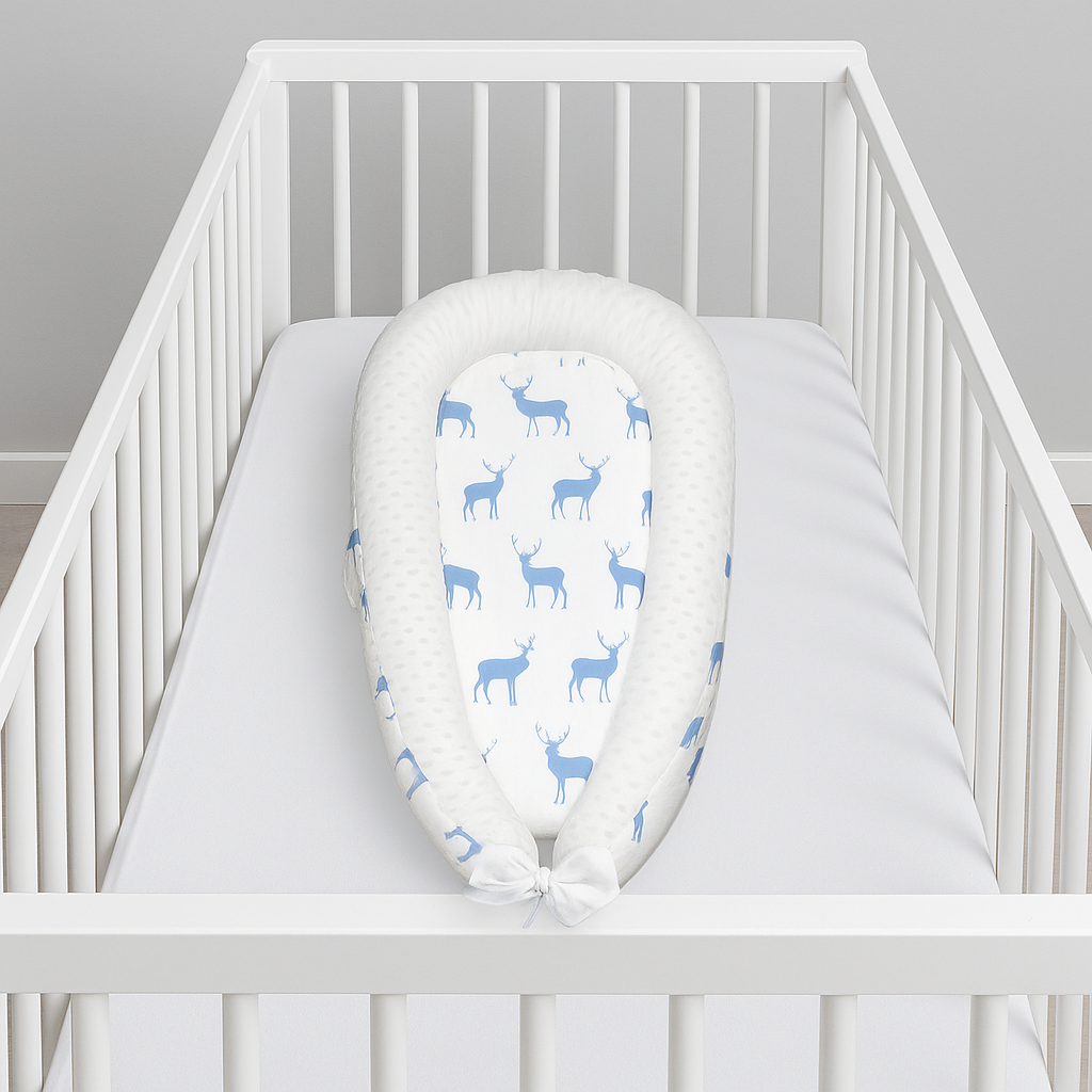 réducteur de lit bebe blanc dans un berceau