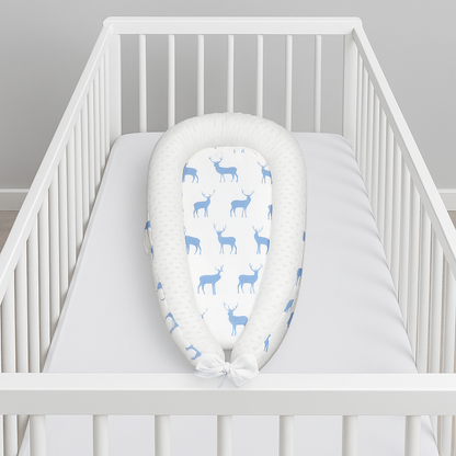 réducteur de lit bebe blanc dans un berceau