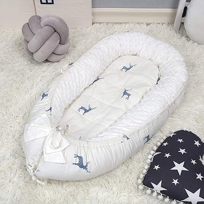 réducteur de lit bebe posé sur un tapis blanc
