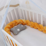 tour de lit bébé orange dans un lit pour bébé à barreaux