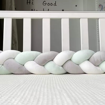 tour de lit bebe tresse grise et verte dans un lit a barreaux
