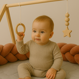 bébé qui joue entouré de sa tresse de lit