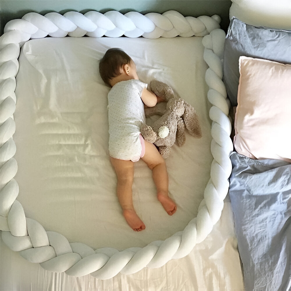 enfant qui fort dans son lit entouré de sa tresse de lit