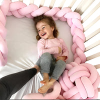 petite fille qui joue dans son lit avec sa tresse de lit