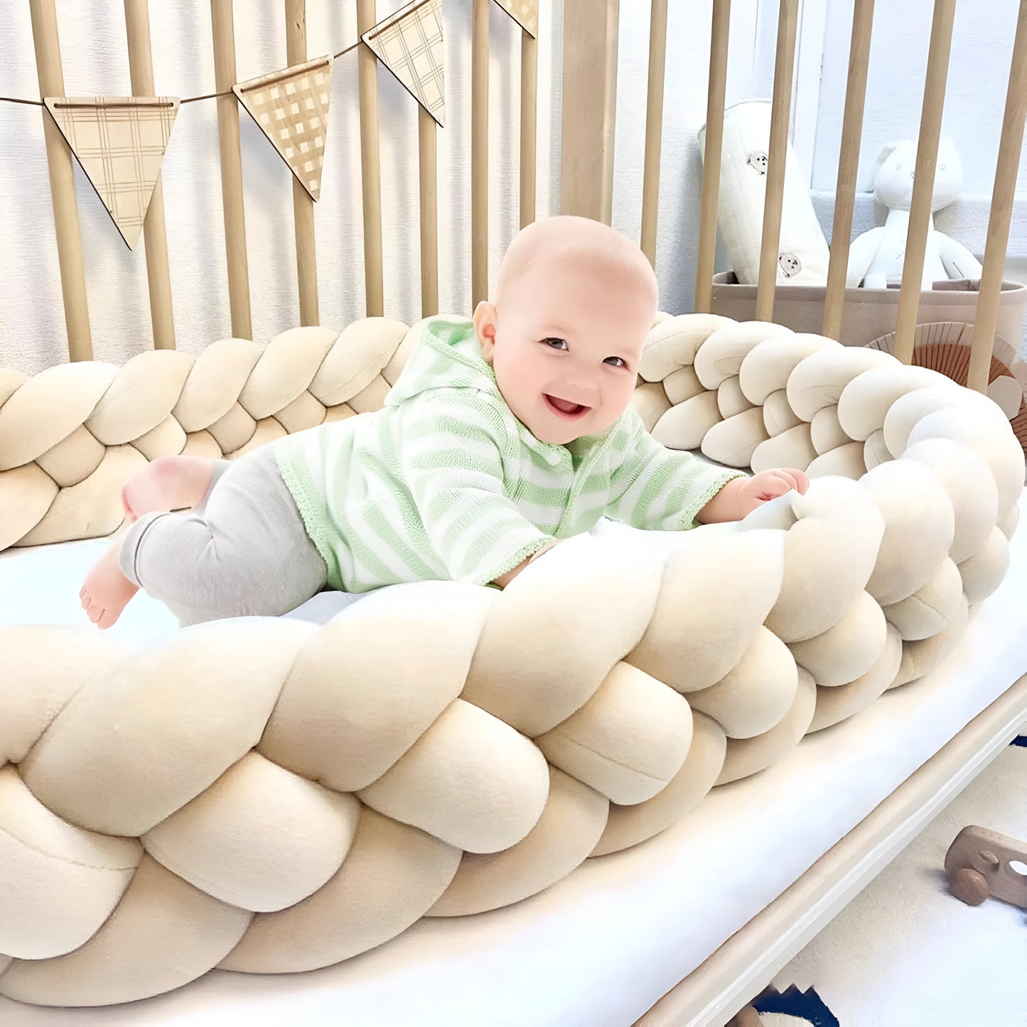 bébé qui joue dans sa tresse de lit beige
