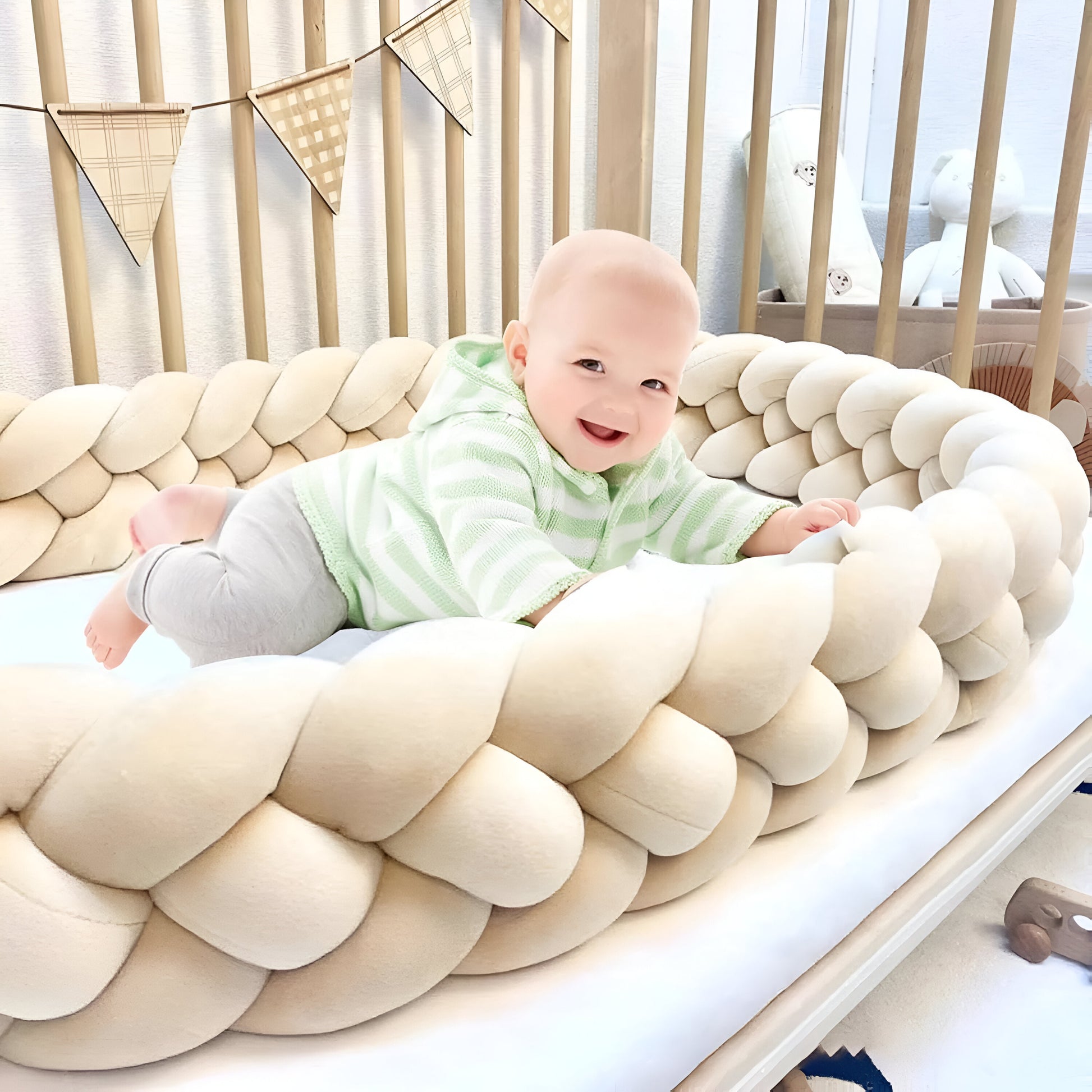 bébé qui joue dans sa tresse de lit beige